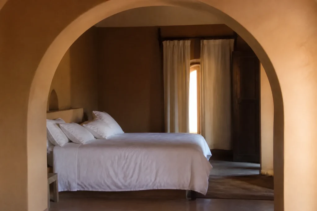 Lit double sous une arche peinte en ocre clair